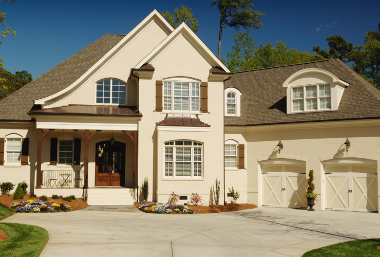 A large white house with a driveway in front of it.