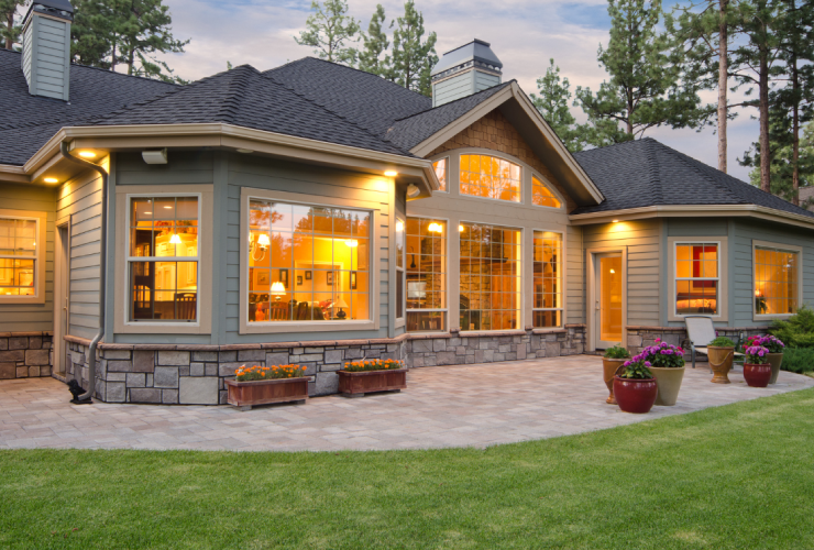 A large house with lots of windows and lights on the outside.