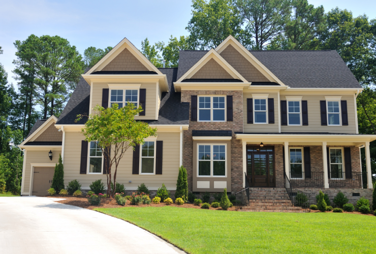 A large house with a lot of green grass on the front lawn.